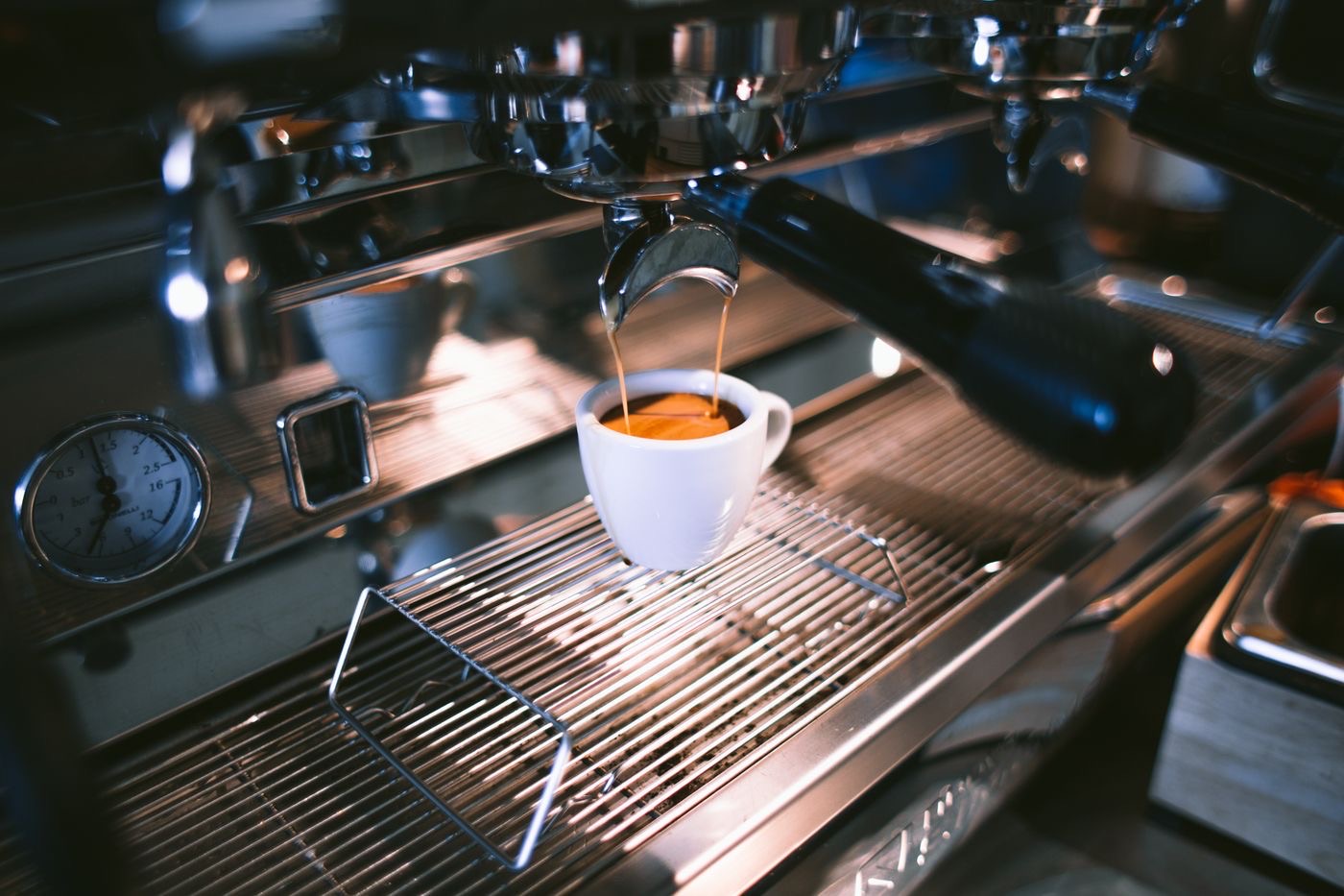 Espresso extracting into a cup on a commercial machine