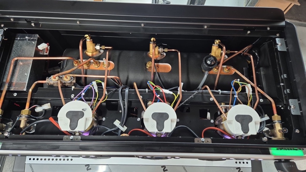 Inside a three-group espresso machine: heating elements, wiring and copper pipework